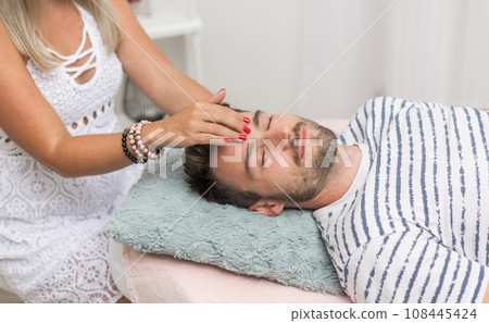The woman healer performing method access or conciousness bars, alternative medicine concept, pseudoscientific method of alternative medicine that focuses on massaging various points on the head The woman healer performing method access or conciousness bars, alternative medicine concept, pseudoscientific method of alternative medicine that focuses on massaging various points on the head 108445424