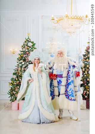 a Father Frost and Snow Maiden in blue costume in the room with christmas trees a Father Frost and Snow Maiden in blue costume in the room with christmas trees 108445549