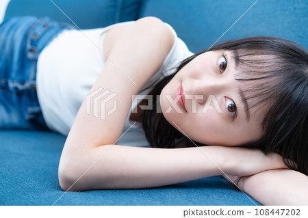 Young woman lying on the sofa and relaxing 108447202