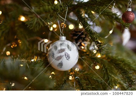 White ball and Christmas toys hanging on the tree 108447820