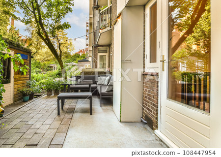 a patio with chairs and trees in the back yard, as seen from an open door on a sunny day a patio with chairs and trees in the back yard, as seen from an open door on a sunny day 108447954