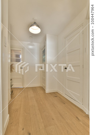 an empty room with white walls and wood flooring on the left side of the room, there is a door to the right an empty room with white walls and wood flooring on the left side of the room, there is a door to the right 108447964