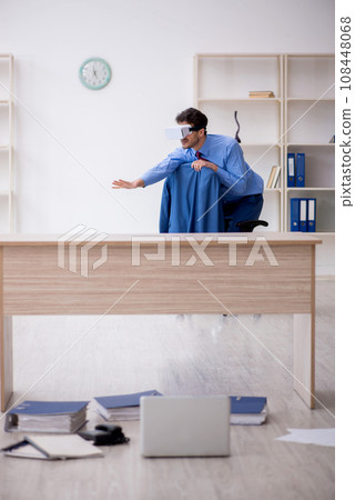 Young male employee enjoying virtual glasses at workplace 108448068