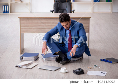 Young male employee unhappy with excessive work in the office 108448098