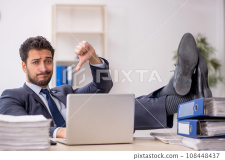 Young male employee and too much work in the office Young male employee and too much work in the office 108448437