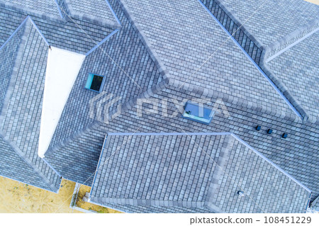 Construction roof of new house is being covered asphalt shingles while building Construction roof of new house is being covered asphalt shingles while building 108451229