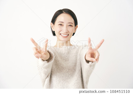 Middle-aged woman making a peace sign with both hands White background 108451510