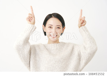 Middle-aged woman pointing upwards, white background Middle-aged woman pointing upwards, white background 108451532