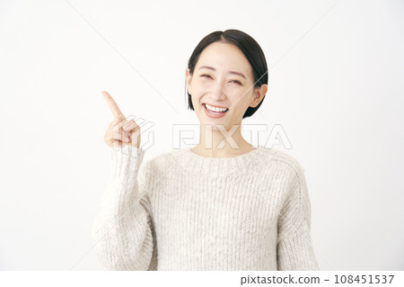 Middle-aged woman pointing to the left white background 108451537