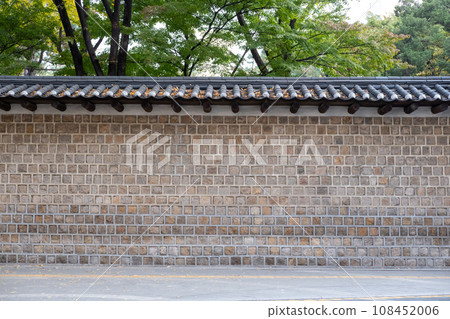 Deoksugung Stonewall Walkway with beautiful autumn foliage. It is the pedestrian footpath that runs next to Deoksugung Palace in Seoul, South Korea 108452006