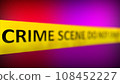 A yellow crime scene tape with the words CRIME SCENE DO NOT CROSS written on it in front of Police Red And Blue Flasher Siren effect. Shallow depth of field. 108452227