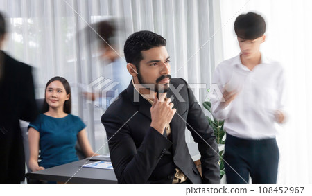 Businessman portrait poses confidently in busy meeting room. Concord Businessman portrait poses confidently in busy meeting room. Concord 108452967