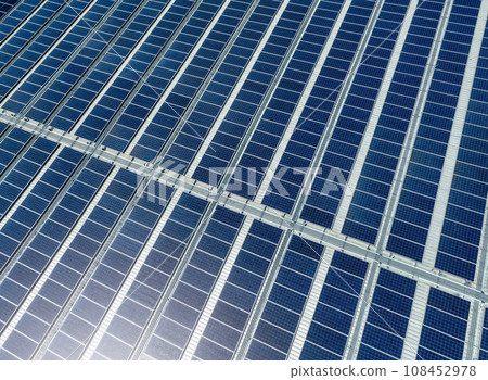 Aerial view of solar panels or photovoltaics on factory roof. Solar power for green energy. Sustainable renewable energy. Solar cell panels generate electricity from sun lights. Photovoltaics or PV. 108452978