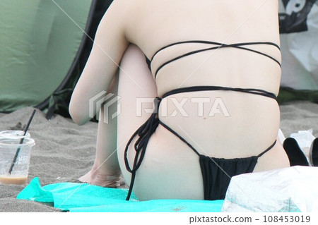 穿著 T 背比基尼的女人在海灘上玩耍,夏日風景 穿著 T 背比基尼的女人在海灘上玩耍,夏日風景 108453019