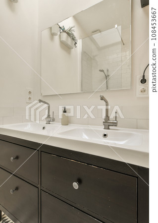 a bathroom with two sinks and a mirror on the wall behind it is a zebra print rug in the floor 108453667
