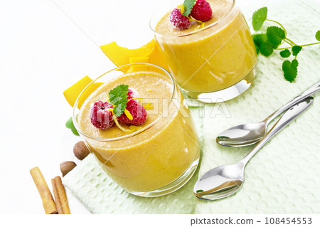 Dessert of yogurt and and pumpkin in two glasses on board Dessert of yogurt and and pumpkin in two glasses on board 108454553