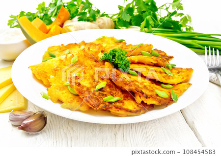 Pancakes of pumpkin with cheese in white plate on light board 108454583