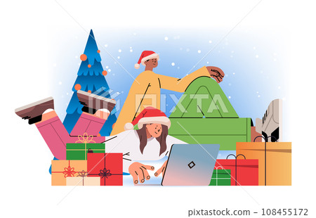 mix race man woman in santa hats near decorated christmas tree using laptop social media communication new year holidays celebration 108455172