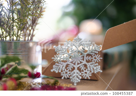 Snowflakes with box of ball baubles and xmas ornaments on the wooden table near christmas tree to preparing decoration for celebration christmas festive holiday and winter seasons at home Snowflakes with box of ball baubles and xmas ornaments on the wooden table near christmas tree to preparing decoration for celebration christmas festive holiday and winter seasons at home 108455387