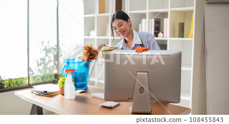 Asian woman cleaning in work room at home. Young woman housekeeper cleaner use a cloth to wipe equipment for working. concept housekeeping housework cleaning Asian woman cleaning in work room at home. Young woman housekeeper cleaner use a cloth to wipe equipment for working. concept housekeeping housework cleaning 108455843