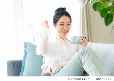 A young woman operating a smartphone A young woman operating a smartphone 108458774