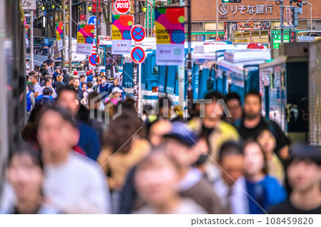 Japan's Tokyo cityscape Halo production. The crowded sidewalk under the elevated train tracks at Shibuya Station. Traffic is restricted at night. In the back is Miyamasu Sakashita = 31st Japan's Tokyo cityscape Halo production. The crowded sidewalk under the elevated train tracks at Shibuya Station. Traffic is restricted at night. In the back is Miyamasu Sakashita = 31st 108459820