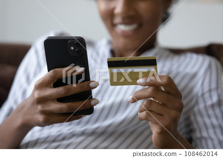 Hands of happy black young shopping woman holding credit card 108462014