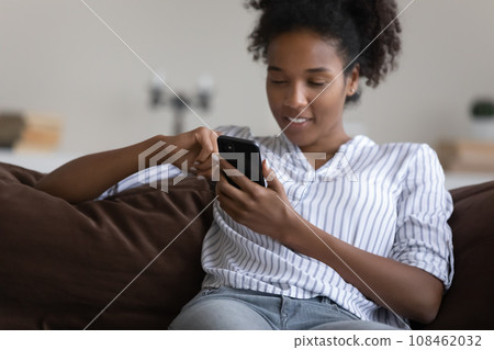 Happy young Black girl, woman resting on couch Happy young Black girl, woman resting on couch 108462032