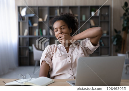 Bored sleepy Black student girl tired of work at laptop Bored sleepy Black student girl tired of work at laptop 108462035