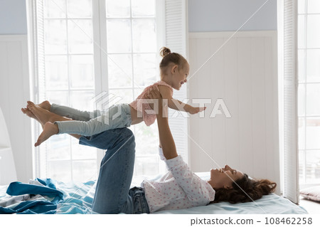 Mother holding, lifting daughter, spend morning, exercising, having fun 108462258