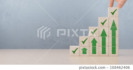 Wooden blocks checklist and green check mark icons with hand on table background. Checklist concept. Green correct sign and up arrow to wooden cube block with copy space Wooden blocks checklist and green check mark icons with hand on table background. Checklist concept. Green correct sign and up arrow to wooden cube block with copy space 108462406