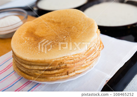 Stack of appetizing flour pancakes in the kitchen during cooking 108465252