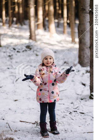 Adorable little girl in big snowy forest. Happy childhood Adorable little girl in big snowy forest. Happy childhood 108465668