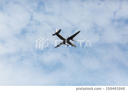A beautiful view of a flying passenger wide-body airliner, an airplane, against a background of white clouds in a blue summer sky. selective focus 108465848