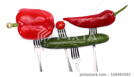 close up of fresh cherry tomato, red peppers and cucumber on forks on white background. Healthy eating and vegetarian food, cooking concept. close up of fresh cherry tomato, red peppers and cucumber on forks on white background. Healthy eating and vegetarian food, cooking concept. 108465881