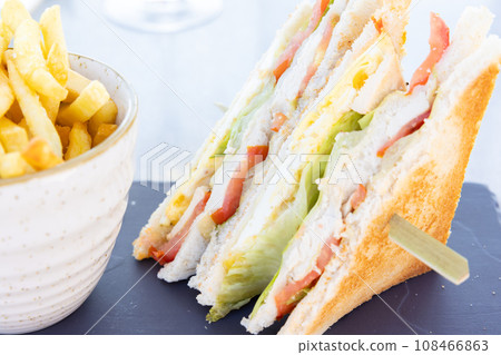 Delicious clubhouse sandwich and fries 108466863
