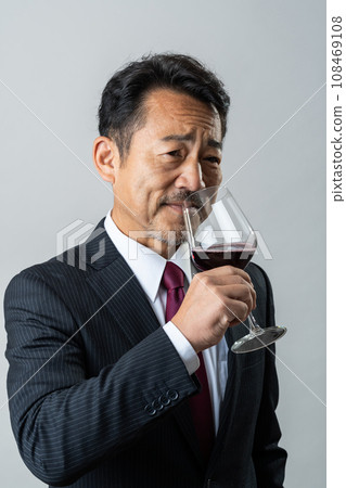 Middle-aged businessman drinking wine 108469108