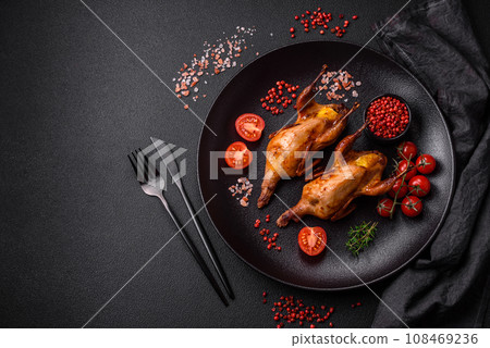 Roasted quail, partridge or pigeon stuffed with orange with spices and herbs 108469236
