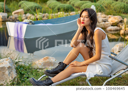 Beautiful young caucasian woman sitting on a sun lounger. 108469645