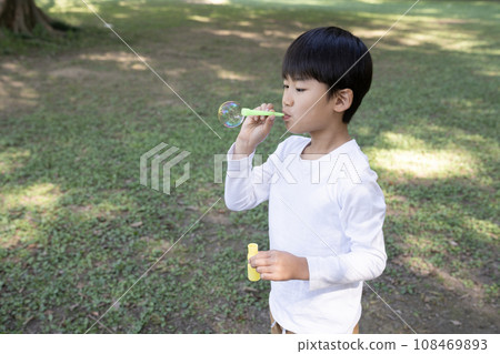 男孩在公園裡製作肥皂泡 108469893