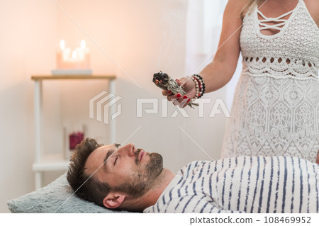 Woman healer doing aromatherapy by smoldering sage, an alternative medicine Woman healer doing aromatherapy by smoldering sage, an alternative medicine 108469952