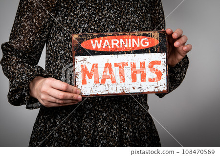 MATHS. Warning sign with text in the hands of a woman MATHS. Warning sign with text in the hands of a woman 108470569