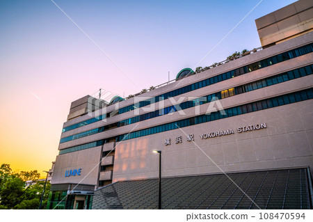 Japan's Yokohama cityscape November - View of contrails and Yokohama Station (east exit) reflected in the sunset 108470594