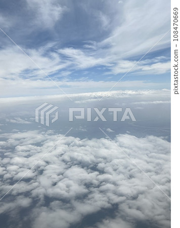 Taking pictures of the clouds outside the window while flying 108470669