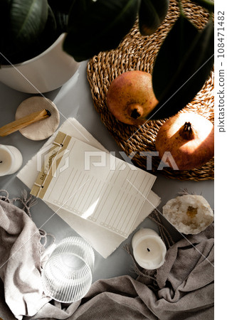 Mockup of daily planner, pomegranates, glass of water, gray blanket, candles, palo santo stick, crystal and a houseplant Mockup of daily planner, pomegranates, glass of water, gray blanket, candles, palo santo stick, crystal and a houseplant 108471482