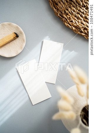 Flat lay of two blank cards sheet on aesthetic pastel grey background with plants and palo santo on sunlight background with shadow 108471491