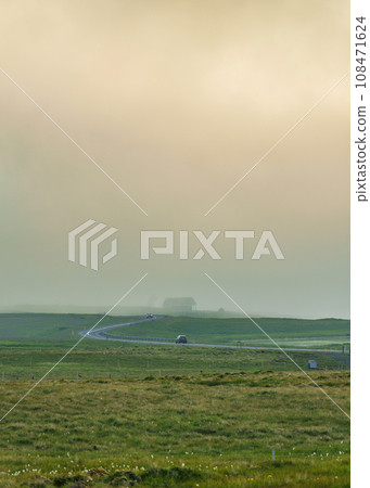 Car driving on curved asphalt road among the meadow in foggy day 108471624