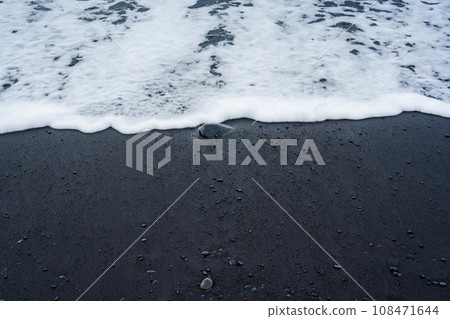 Sea wave on volcanic black sand beach in summer Sea wave on volcanic black sand beach in summer 108471644
