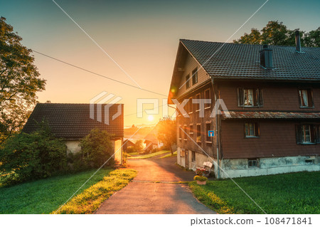 Sunrise on wooden house and pathway in peaceful village at Hirzel, Switzerland 108471841