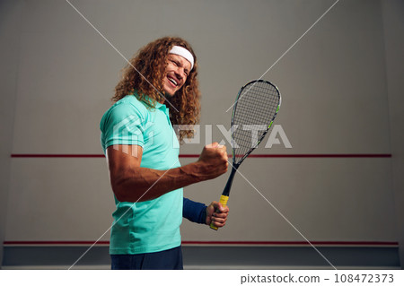 Satisfied squash player clenching fist rejoicing win in game 108472373